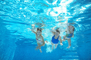 Family swim in pool or sea underwater, happy active mother and children have fun in water