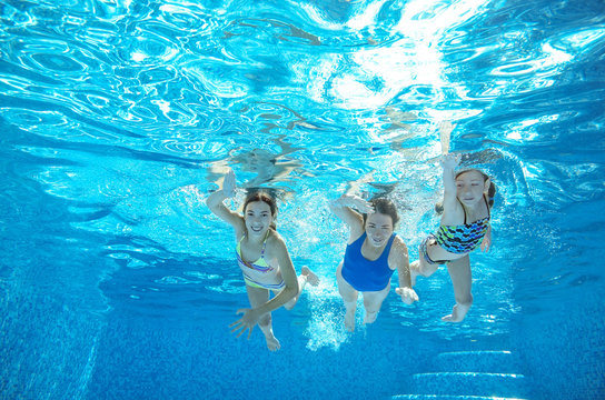 Family swim in pool or sea underwater, happy active mother and children have fun in water