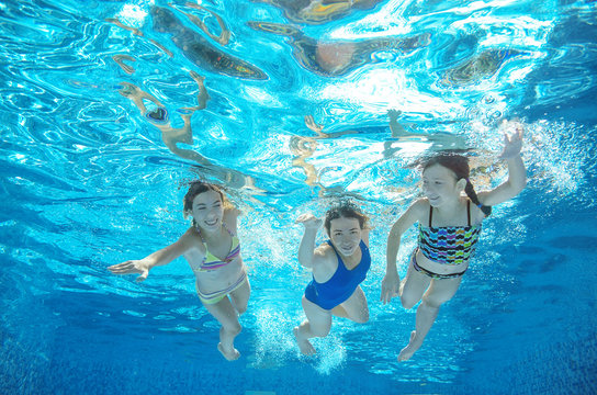 Family swim in pool or sea underwater, happy active mother and children have fun in water
