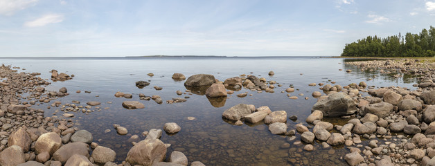 panorama of the bay of Lake Ladoga in the European part of Russia with stones, trees and calm water