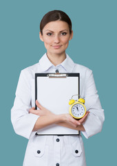 Portrait of a smiling nurse with a clipboard and a clock
