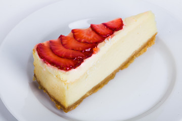 cheesecake with jelly and strawberry slices on a plate close-up