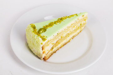 biscuit cake slice cheesecake with pistachios on a plate close