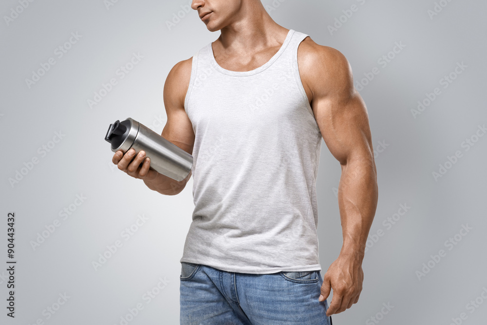 Wall mural Muscular fitness male holding protein shake bottle