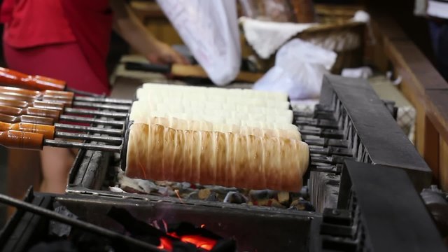 Kurtoskalacs or traditional romanian chimney cake cooking over burning embers