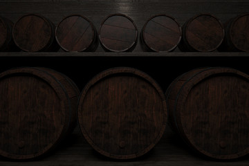 Rows of small and large barrels on wooden shelves highlighted a lamp.