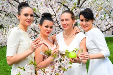 Girls with champagne celebrating in sakura's garden.