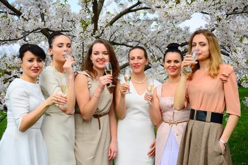 Girls with champagne celebrating in sakura's garden.