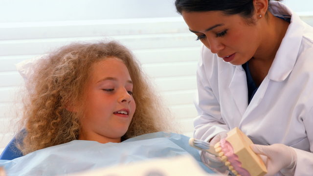 Dentist showing a patient how to brust their teeth