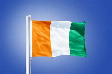 Flag of Cote d'Ivoire flying against a blue sky