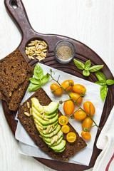yellow cherry tomatoes and avocado with pine nuts. basil leaves.