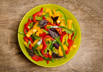 salad from bell pepper and basil on wooden background