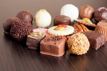 Delicious chocolate candies on wooden background