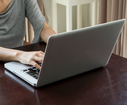 Woman hands using a laptop at home in day time (Focus Hand)