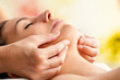 Hands massaging female chin.