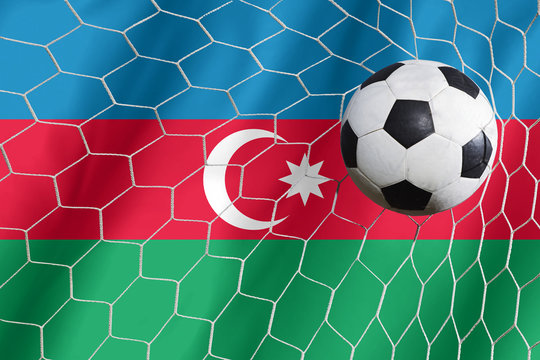 Soccer ball and national flag of Azerbaijan lies on the green gr