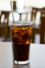 glass of cola with ice on a table
