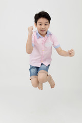 Happy asian boy is jumping at studio.