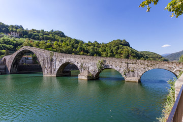 Fototapeta na wymiar The medieval Devil's bridge across the Serchio river in the village of Borgo a Mozzano in the province of Lucca, Tuscany, Italy