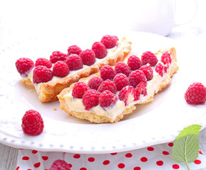 Tart with custard, raspberries and white chocolate adorned with mint
