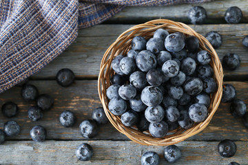 Blueberries in basket on a blue wooden background