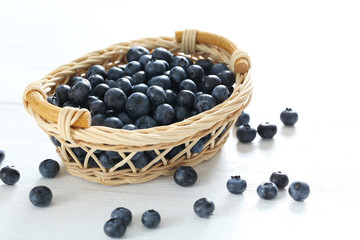 Blueberries in basket on a white wooden background
