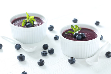 Delicious blueberry mousse in bowls on wooden table