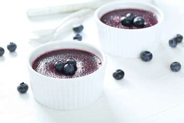 Delicious blueberry mousse in bowls on wooden table