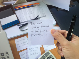 Hand take paper note with busy things on work table