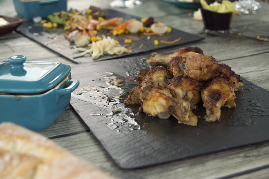 roasted chicken drumsticks on the table, on slate plate.