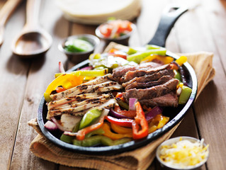 chicken and steak mexican fajitas in iron skillet
