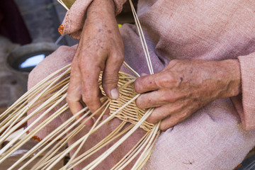 craftsman making wicker baskets traditionally