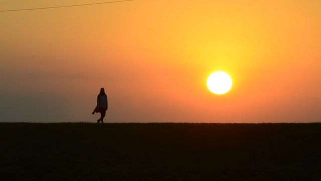 Frau geht in der untergehende Abendsonne spazieren