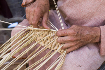 craftsman making wicker baskets traditionally