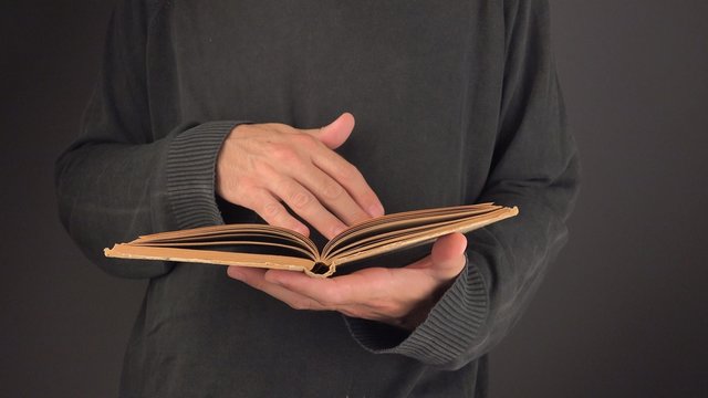 Man turning yellow pages of old vintage book in search for text and valuable information, 4k uhd footage