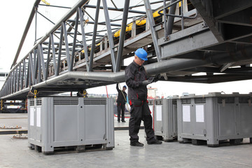Fototapeta premium Workers in coveralls and hardhat working at industrial site
