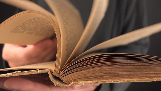 Man turning yellow pages of old vintage book in search for text and valuable information, 4k uhd footage