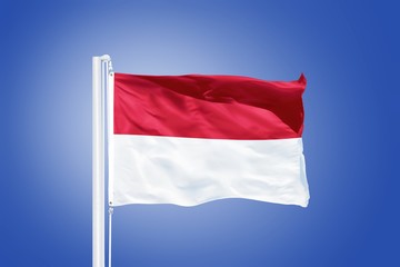 Flag of Indonesia flying against a blue sky
