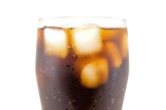 a large glass of cola with ice cubes closeup isolated on white background