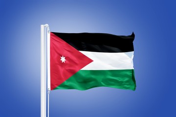 Flag of Jordan flying against a blue sky