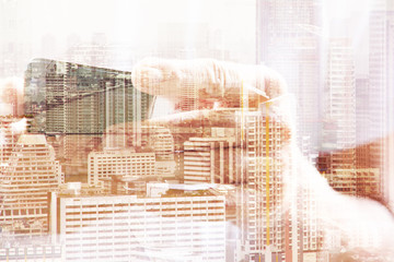 Double exposure of man using smart phone and cityscape background