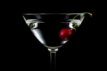 glass of drink with cherry closeup isolated on black background

