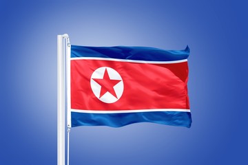 Flag of North Korea flying against a blue sky