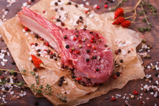 Fresh meat on the bone steak with spices and herbs,on a dark background