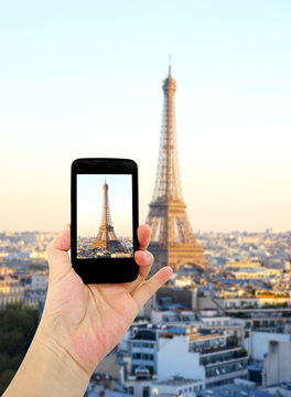 Woman hand taking pictures in front of Eiffel Tower, Cell phone
