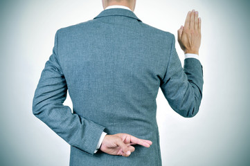 young man swearing an oath, crossing his fingers in his back