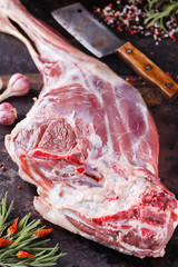 Raw lamb leg marinated with spices, garlic and rosemary, with a young potato.selective focus