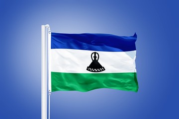 Flag of Lesotho flying against a blue sky