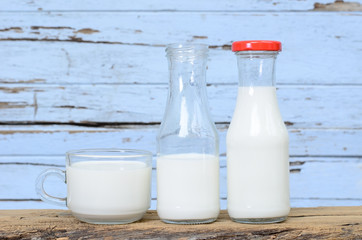 Milk bottle and milk glass put on old wood.