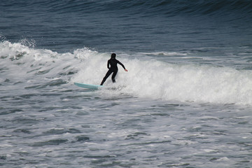 A Surfer Riding on a Wave in the Ocean Sea.